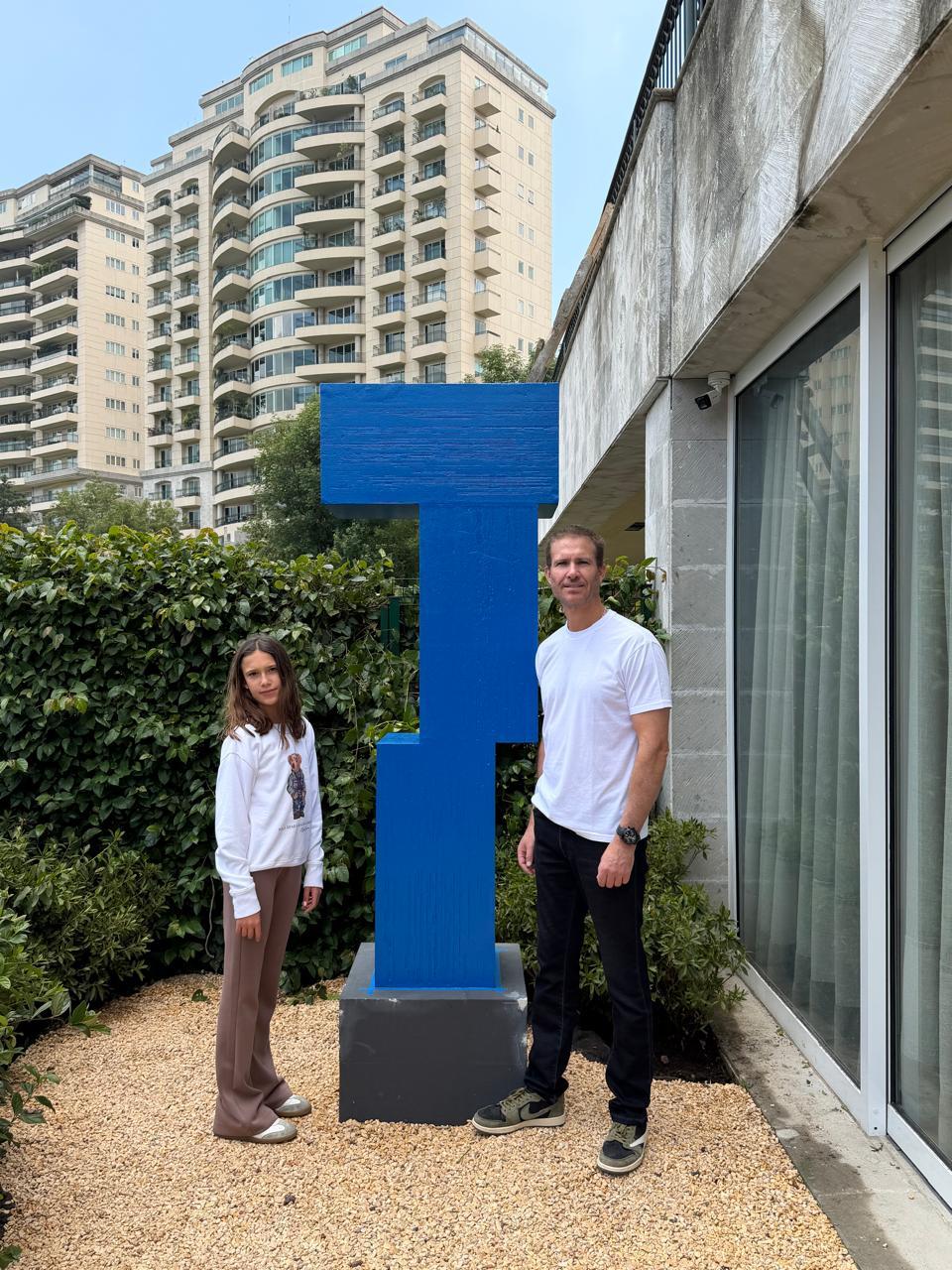 Escultura geométrica azul en un jardín